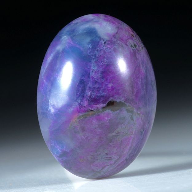Sugilith mit Richterit, Südafrika, 30.5x22x12mm 56.04ct. Ovaler Cabochon
