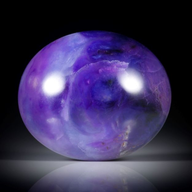 Sugilith mit Richterit 58.12ct. ovaler Cabochon ca.31x26x10mm